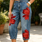 Jeans da donna a gamba larga con stampa floreale artistica.