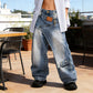 Jeans in denim a gamba larga con vita asimmetrica da donna